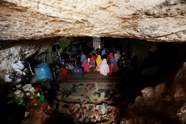 Internally displaced children attend a class inside a cave in the rebel-controlled village of Tramla, in Idlib province, Syria March 27, 2016. A group of people, who live in a cave, have set up a school for children during the day. The cave accommodates around 120 students, divided into two shifts. (Photo by Khalil Ashawi/Reuters)