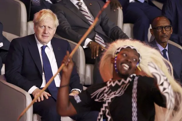British Prime Minister Boris Johnson, left, and Rwandan President Paul Kagame, right, look at traditional dancers performing during the opening ceremony of the Commonwealth Heads of Government Meeting (CHOGM) on Friday, June 24, 2022 in Kigali, Rwanda. Leaders of Commonwealth nations are meeting in Rwanda Friday in a summit that promises to tackle climate change, tropical diseases and other challenges deepened by the COVID-19 pandemic. (Photo by Dan Kitwood/Pool Photo via AP Photo)