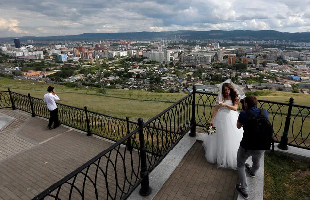 A photographer takes pictures of a bride during a wedding in the Siberian city of Krasnoyarsk, Russia July 1, 2016. (Photo by Ilya Naymushin/Reuters)