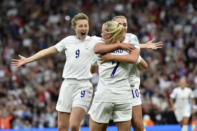 England's Beth Mead, center, celebrates with Ellen White, left, and Georgia Stanway after scoring the opening goal during the Women Euro 2022 soccer match between England and Austria at Old Trafford in Manchester, England, Wednesday, July 6, 2022. (Photo by Rui Vieira/AP Photo)