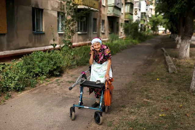 Olga Alekseevna, 96, walks with the help of a walker towards her daughter's house in Kramatorsk, as Russia's invasion of Ukraine continues, in Donetsk region, Ukraine on August 14, 2022. (Photo by Nacho Doce/Reuters)