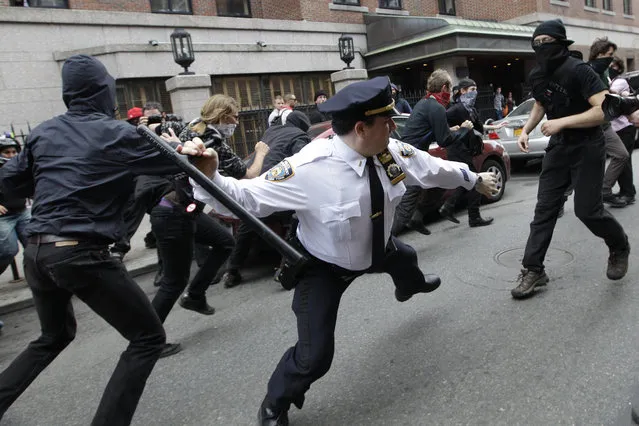 A police lieutenant swings his baton at an Occupy Wall Street activists on Tuesday, May 1, 2012 in New York.  (Photo by Mary Altaffer/AP Photo)