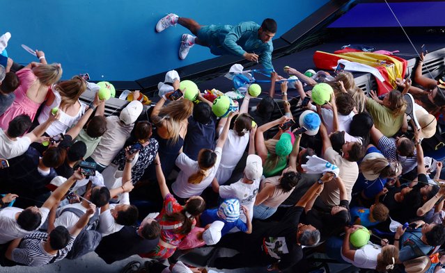 Spain’s Carlos Alcaraz on January 19, 2025 signs autographs for tennis fans after his victory at the Australian Open against Jack Draper, the British No 1, who was forced to retire. (Photo by Edgar Su/Reuters)