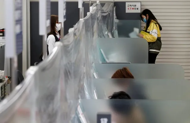 A bank teller wearing a protective face mask stands at a counter where a plastic curtain is installed in order to prevent infections following the coronavirus disease (COVID-19) outbreak, at the Higashinakano branch of MUFG Bank in Tokyo, Japan, April 24, 2020. (Photo by Kim Kyung-Hoon/Reuters)