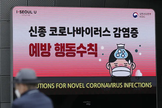 A man wearing a face mask sits near a screen showing precautions against the new coronavirus in Seoul, South Korea, Tuesday, May 12, 2020. As South Korea grapples with a new spike in coronavirus infections thought to be linked to nightspots in Seoul, including several popular with gay men, it's also seeing rising homophobia that's making it difficult for sexual minorities to come forward for diagnostic tests. (Photo by Lee Jin-man/AP Photo)