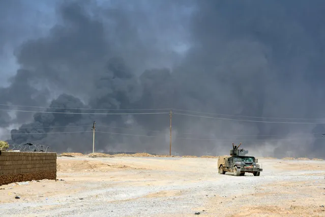 Smoke rises from clashes with Islamic State militants on the outskirt of Al Qayyarah, Iraq, August 14, 2016. Picture taken August 14, 2016. (Photo by Reuters/Stringer)