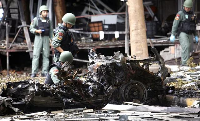 Thai bomb squad officers examine the wreckage of a car after an explosion outside a hotel in Pattani province, southern Thailand, Wednesday, August 24, 2016. Two bombs exploded late Tuesday near a hotel in insurgency-wracked southern Thailand. (Photo by Sumeth Panpetch/AP Photo)