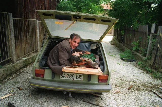 A picture taken on June 27, 1992 shows man supporting the head of a Bosnian woman badly injured by a Serbian mortar shelling in Sarajevo as she is transported in the back of a car to the hospital. Serbia announced the arrest of former Bosnian Serb military chief Ratko Mladic on May 26, 2011 ending a 16-year manhunt for the general accused of masterminding Europe's worst massacre since World War II. President Boris Tadic confirmed reports that the 69-year-old had been detained by Serbian security forces, saying the capture would bolster Serbia's “moral credibility in the world”. (Photo by Christophe Simon/AFP Photo)