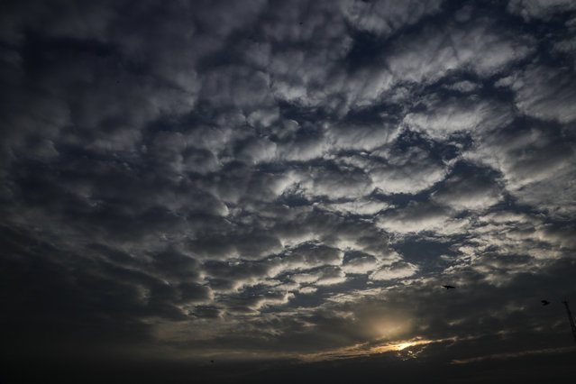 Sun sets behind a patterned cloud formed over the city in Kolkata, West Bengal state, India, Monday, May 18, 2020. A cyclonic storm “Amphan” has intensified into a super cyclone over the Bay of Bengal and expected a landfall near Sundarbans, south of Kolkata, on May 19 evening. A red alert has been initiated to sea bound fishermen and disaster management teams started evacuating villagers from the sea front. (Photo by Bikas Das/AP Photo)