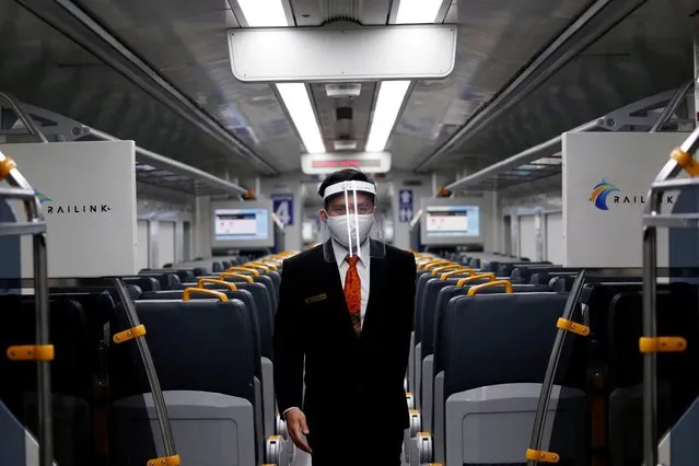 An employee wearing a protective mask and face shield walks inside a Railink train after the government eased restrictions following the coronavirus disease (COVID-19) outbreak in Jakarta, Indonesia, July 2, 2020. (Photo by Willy Kurniawan/Reuters)
