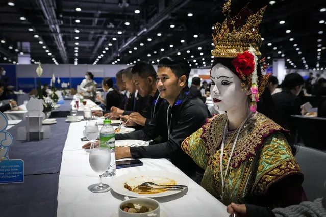 A Thai traditional dancer in costume finishes her lunch at the Asia-Pacific Economic Cooperation APEC summit, Thursday, November 17, 2022, in Bangkok, Thailand. (Photo by Anupam Nath/AP Photo)