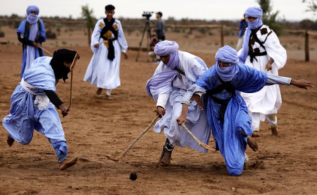 Moroccan nomads dressed in traditional garments take part in a sand hockey match during the Nomads Festival in Mhamid El-Ghizlane in Morocco's southern Sahara desert on April 12, 2025. (Photo by Abdel Majid Bziouat/AFP Photo)