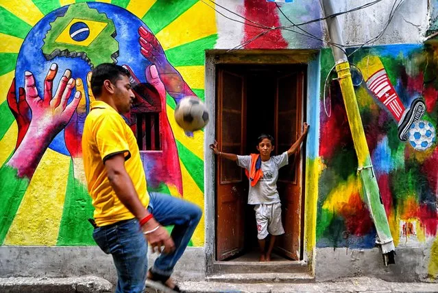 A member of the Dishari club seen playing football in front of street art during the celebration of the FIFA World Cup 2022 in Kolkata on November 26, 2022. (Photo by Avishek Das/SOPA Images/Rex Features/Shutterstock)
