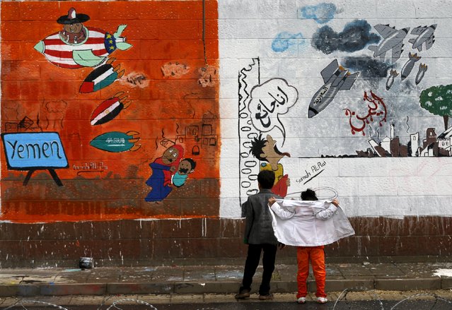 Children look at graffiti painted by pro-Houthi activists during a campaign against Saudi-led air strikes on the wall of the Saudi embassy in Sanaa August 2, 2015. (Photo by Khaled Abdullah/Reuters
