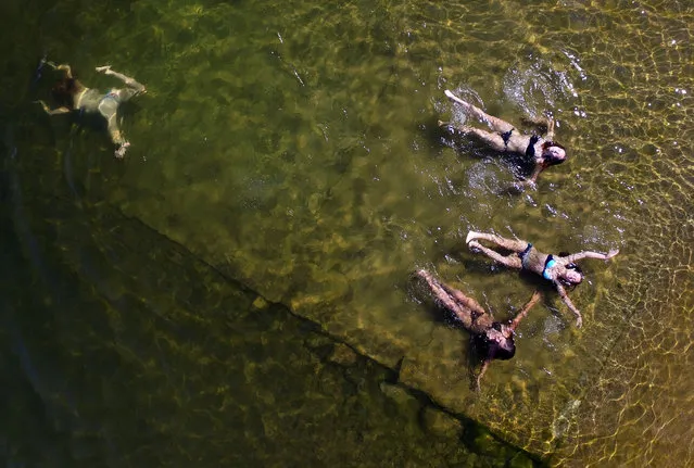 An aerial view shows women swimming in the Yenisei River on a hot summer day, with the air temperature at about 32 degrees Celsius (89.6 degrees Fahrenheit), outside Krasnoyarsk, Siberia, Russia, June 28, 2017. (Photo by Ilya Naymushin/Reuters)