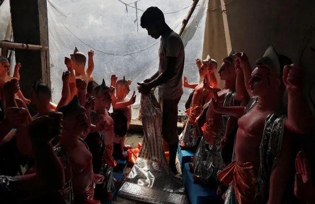 An artisan dresses up an idol of Lord Vishwakarma, the Hindu deity of architecture and machinery, inside a workshop ahead of the Vishwakarma festival in Kolkata, India, September 14, 2016. (Photo by Rupak De Chowdhuri/Reuters)