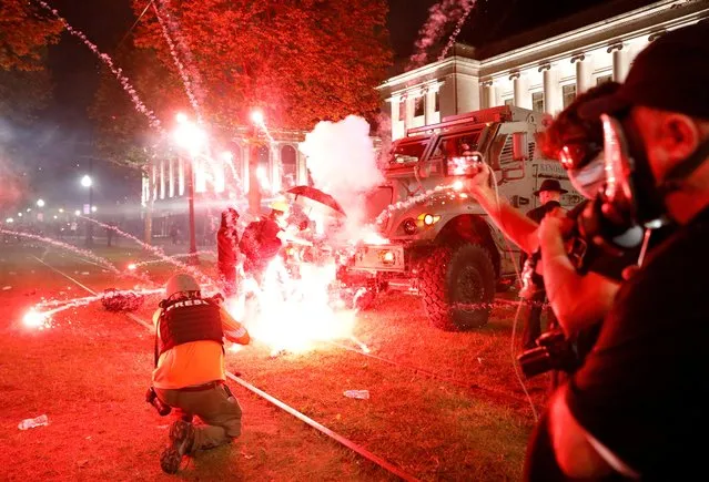 Flares go off in front of a Kenosha Country Sheriff Vehicle as demonstrators take part in a protest following the police shooting of Jacob Blake, a Black man, in Kenosha, Wisconsin, U.S. August 25, 2020. (Photo by Brendan McDermid/Reuters)