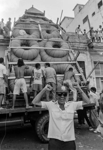 A man gestures as a makeshift boat is lowered from a roof where it was constructed by would-be emigrants, as they take it to launch into the Straits of Florida towards the U.S., on the last day of the 1994 Cuban raft exodus in Havana, in this September 13, 1994 file photo. (Photo by Rolando Pujol Rodriguez/Reuters)