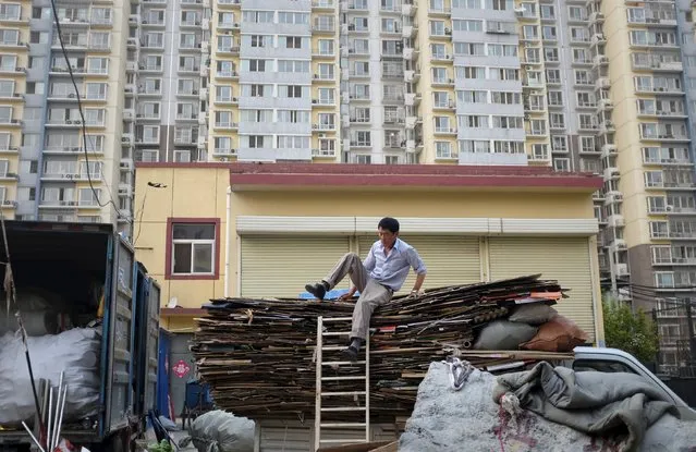 A rag-and-bone man tries to come down from a truck in front of an apartment block, in Beijing, China, June 15, 2015. Chinese leaders will signal that growth is their priority over reform for the world's second-biggest economy by setting a growth target of around 7 percent in their next long-term plan even as the economy loses momentum, policy insiders say. The Communist Party's central committee will meet from October 26-29 to set out their 13th Five-Year plan, a blueprint for economic and social development between 2016 and 2020. (Photo by Jason Lee/Reuters)