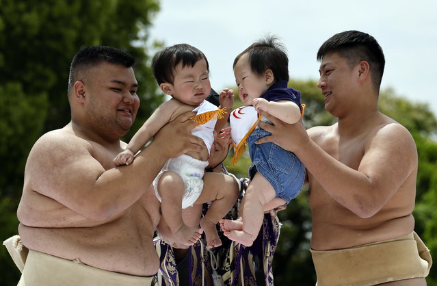 Amateur sumo wrestlers hold babies during Nakizumo, a baby crying contest at Sensoji Temple in Tokyo's Asakusa district, Japan, 26 April 2025. Some 160 babies born in 2024 participated in the spring event, praying for their good health and growth. The baby who begins to cry first and the loudest is declared the winner, as it is said in Japan that a crying baby grows healthy and strong. (Photo by Franck Robichon/EPA)
