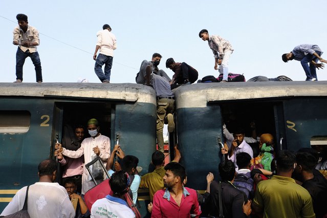 Bangladeshi Muslims maneuver their way on the roof of an overcrowded train to travel home for Eid al-Fitr celebrations, at a railway station in Dhaka, Bangladesh, Tuesday, April 9, 2024. (Photo by Mahmud Hossain Opu/AP Photo)