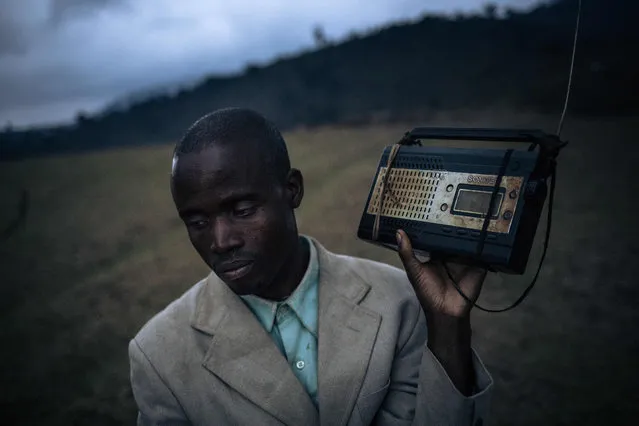 A displaced man stands at the top of a hill to pick up the radio signal and listen to the news near the internally displaced persons camp of Bijombo, South Kivu Province, eastern Democratic Republic of Congo, on October 9, 2020. Since February 2019, the landlocked highlands of Fizi and Uvira in South Kivu have been the scene of clashes and retaliation attacks by armed groups claiming to defend the interests of their respective communities. According to the United Nations High Commissioner for Human Rights, approximately one hundred villages have been destroyed and burned, several dozen civilians have been killed and thousands of people have been forced to flee their homes. (Photo by Alexis Huguet/AFP Photo)