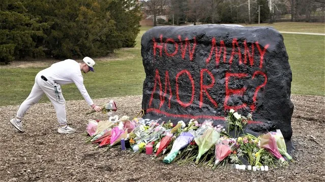 A student leaves flowers at The Rock on the grounds of Michigan State University, in East Lansing, Mich., Tuesday, February 14, 2023. A gunman killed several people and wounded others at Michigan State University. Police said early Tuesday that the shooter eventually killed himself. (Photo by Paul Sancya/AP Photo)