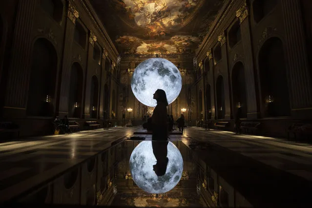 People visit UK artist Luke Jerram's artwork “Museum of the Moon” at Painted Hall in the Old Royal Naval College, London, United Kingdom on December 28, 2022. “Museum of the Moon” in three dimensions is created using NASA photographs. NASA imagery-based artwork depicting a lunar scene is hanged against the Painted Hall's Baroque interior. (Photo by Rasid Necati Aslim/Anadolu Agency via Getty Images)