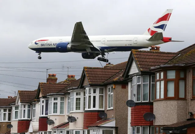 An aircraft  passes over houses as it lands at Heathrow Airport near London, Britain, December 11, 2015. (Photo by Neil Hall/Reuters)