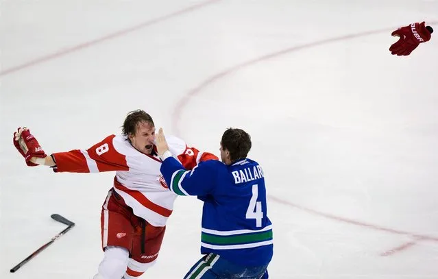 The Detroit Red Wings' Justin Abdelkader, left, and the Vancouver Canucks' Keith Ballard fight during the second period of an NHL hockey game in Vancouver, British Columbia, on April 20, 2013. (Photo by Darryl Dyck/The Canadian Press via AP Photo)