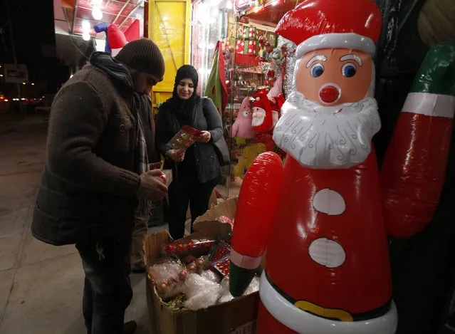 Iraqi people shop for Christmas decorations at a market in Baghdad, December 24, 2014. (Photo by Ahmed Saad/Reuters)