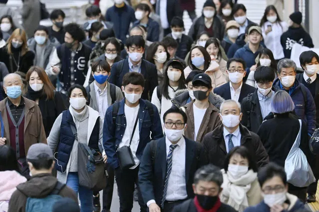 People wear face masks as they make their way through a street in Tokyo Friday, November 27, 2020. Tokyo reported 570 new COVID-19 cases on Friday, a new record for Japan’s capital city as the country faces a surge in infections. (Photo by Yohei Nishimura/Kyodo News via AP Photo)