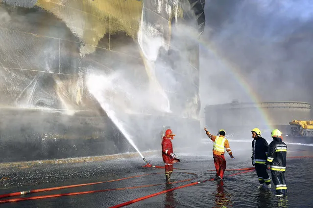 A rainbow is seen as fire-fighters work to put out a fire at a storage oil tank in the port of Es Sider January 2, 2015. Libya has extinguished a fire at oil storage tanks at the country's biggest oil port, Es Sider, that had been raging for a week, officials said on Friday. (Photo by Reuters/Stringer)