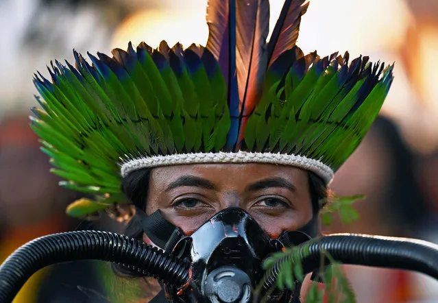 An indigenous woman participates in a protest march during the Terra Livre Indigenous camp in Brasilia on April 26, 2023. The camp will run until April 29, 2023, and is focused on raising awareness about indigenous rights and land issues and promoting indigenous culture. (Photo by Carl de Souza/AFP Photo)