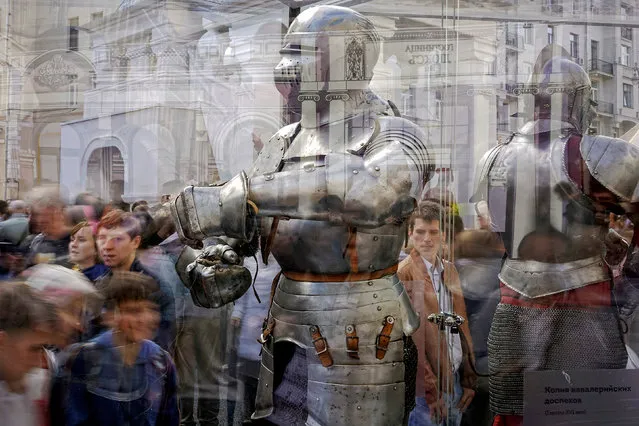 People are reflected in a showcase as they observe a historic armoured suit of the Middle Ages during the celebrations for the City Day in Moscow, Russia September 10, 2016. (Photo by Maxim Zmeyev/Reuters)