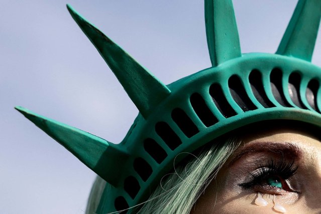 A woman wearing a Statue of Liberty-style headpiece attends a protest in Washington, DC, on Wednesday, November 5, 2025. The protest marked one year since Donald Trump was elected president a second time. (Photo by Evelyn Hockstein/Reuters)