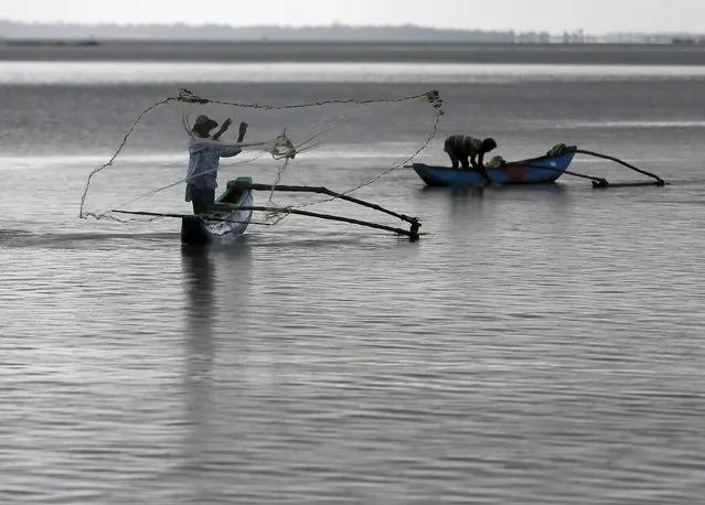 A fisherman throws his net to catch fish in a lagoon in Batticaloa November 24, 2015. (Photo by Dinuka Liyanawatte/Reuters)