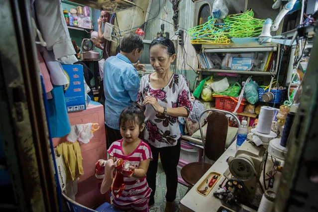 Nguyen Thi Kim Ngoc and her husband Nguyen Van Truong are seen with their granddaughter in their 6.7- square- metre home in Ho Chi Minh City on May 3, 2018. (Photo by Thanh Nguyen/AFP Photo)
