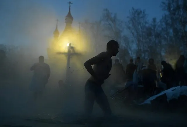 People take a dip during celebrations of the Orthodox Christian feast of Epiphany at the Achairsky convent in Omsk Region, Russia on January 19, 2021. (Photo by Alexey Malgavko/Reuters)