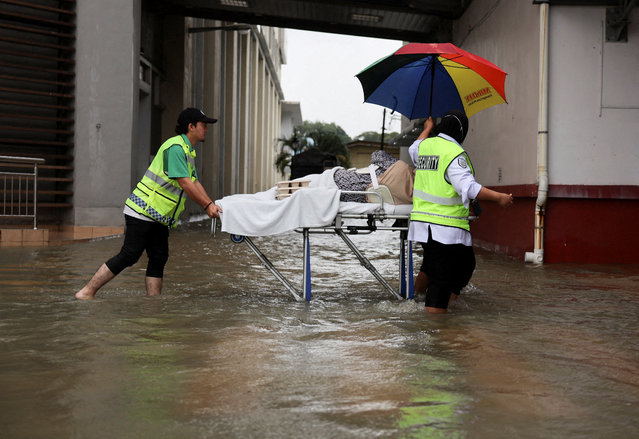 Hospital staff push a patient on a stretcher through floodwater after heavy rain caused flooding in northern states of Malaysia, bordering Thailand, at Kangar, Malaysia on November 26, 2025. (Photo by Hasnoor Hussain/Reuters)