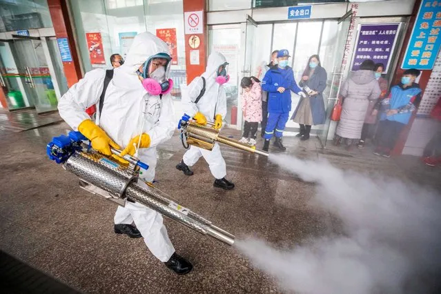 This photo taken on February 7, 2021 shows workers disinfecting a long distance bus station in Bijie, in China's southwest Guizhou province, as authorities prepare for a travel peak ahead of the Lunar New Year, which ushers in the Year of the Ox on February 12. (Photo by AFP Photo/China Stringer Network)