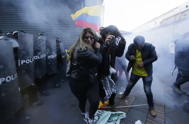 Supporters of former President Rafael Correa clash with police, near the government palace during a rally in support of Correa after a judge ordered him jailed for failing to appear in court as required as part of a kidnapping probe, in Quito, Ecuador, Thursday, July 5, 2018. Chief prosecutor Paul Perez demanded Correa's arrest and extradition from Belgium, where he currently resides. (Photo by Dolores Ochoa/AP Photo)