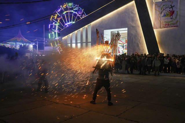 A man wears a “torito” fireworks display during the celebration of the Black Christ of Esquipulas the night before its feast day in Esquipulas Palo Gordo, in Guatemala's San Marcos department, Tuesday, January 14, 2025. (Photo by Moises Castillo/AP Photo)
