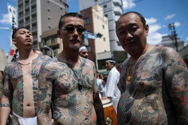Participants pose to show their traditional Japanese tattoos (Irezumi), related to the Yakuza, during the annual Sanja Matsuri festival in the Asakusa district of Tokyo on May 20, 2018. Sanja Matsuri festival is a celebration for the three founders of Sensoji Temple in the Asakusa neighbourhood with nearly two million people visiting during the three-day event. (Photo by Behrouz Mehri/AFP Photo)