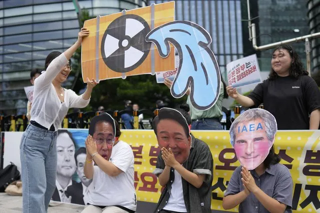 Students wearing masks of, from left, Japanese Prime Minister Fumio Kishida, South Korean President Yoon Suk Yeol and Rafael Mariano Grossi, director general of the International Atomic Energy Agency, perform during a rally to oppose Japanese government's plan to release treated radioactive water into the sea from the Fukushima nuclear power plant, in Seoul, South Korea, Friday, July 7, 2023. (Photo by Lee Jin-man/AP Photo)