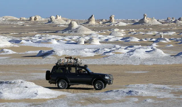 Desert safari vehicles drive along in the White Desert, Egypt, 07 February 2021. Egypt is unique in the variety of desert oasis as Al Farafra Oasis, Swia and Al Bahria Oasis that attract tourists from all over the world to enjoy safaris in the sunny weather. The Supreme Council of Antiquities introduced the “Spend Winter in Egypt” initiative in January 2021 to encourage domestic tourism. Flights to various destinations are offered at flat rates from 15 January to 28 February and a there is a 50 per cent discount for Egyptians on tickets at the archaeological areas and museums in various governorates in January and February. The ministry has emphasized the importance to keep precautionary measures and health safety controls at all sites. (Photo by Khaled Elfiqi/EPA/EFE)