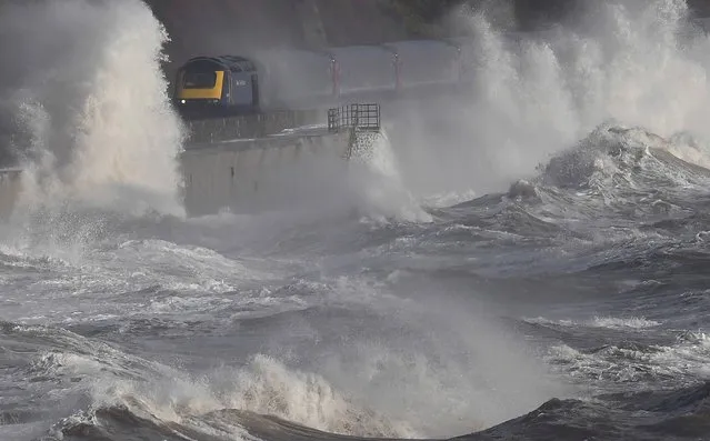 Waves hit a train during heavy seas and high winds in Dawlish in south west Britain, February 2, 2017. (Photo by Toby Melville/Reuters)