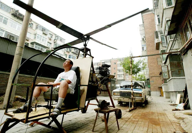 A self-styled Chinese inventor tests his homemade helicoptor next to his apartment in Beijing June 25, 2003. Yu Jun follows in the footsteps of his younger brother who lost his life in a national park in central China at the end of a 20 year search for the legendary “Bigfoot”, and intends to continue the quest from the sky. Without any formal education in aerospace science, Yu Jun spent five years constructing the helicopter from spare parts belonging to a dilapidated “Lada” automobile (in back). (Photo by Reuters/China Photo)