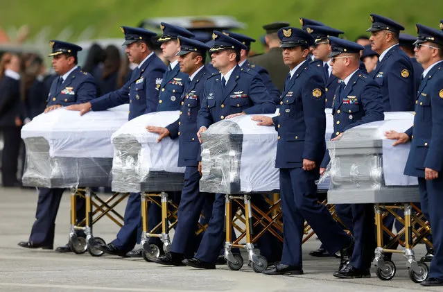 Military personnel unload a coffin with the remains of Brazilian victims who died in an accident of the plane that crashed into the Colombian jungle with Brazilian soccer team Chapecoense, at the airport from where the bodies will be flown home to Brazil, in Medellin, Colombia December 2, 2016. (Photo by Jaime Saldarriaga/Reuters)