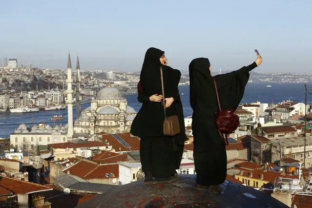 Young women take selfie photographs in front of the New Mosque by the Bosphorus strait in Istanbul, Turkey January 12, 2016. A Syrian suicide bomber is thought to be responsible for an attack which killed at least ten people including foreigners in the heart of Istanbul's historic Sultanahmet tourist district on Tuesday, President Tayyip Erdogan said. There was a high probability Islamic State militants were behind the blast near the Blue Mosque and Hagia Sophia, major tourist sites in the centre of one of the world's most visited cities, two senior Turkish security officials told Reuters. (Photo by Murad Sezer/Reuters)